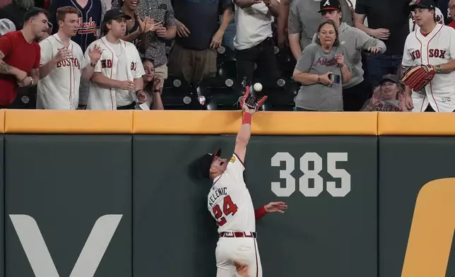Atlanta Braves left fielder Jarred Kelenic catches a fly ball at the wall to retire Boston Red Sox' Garrett Cooper in the sixth inning of a baseball game Wednesday, May 8, 2024, in Atlanta. (AP Photo/John Bazemore)