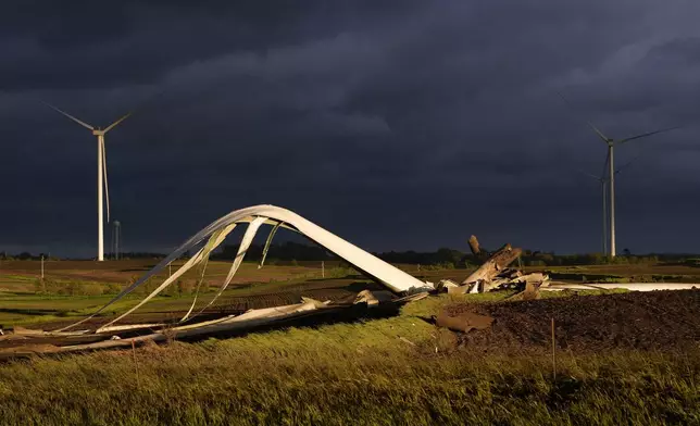 The remains of a tornado-damaged wind turbine touch the ground in a field, Tuesday, May 21, 2024, near Prescott, Iowa. (AP Photo/Charlie Neibergall)