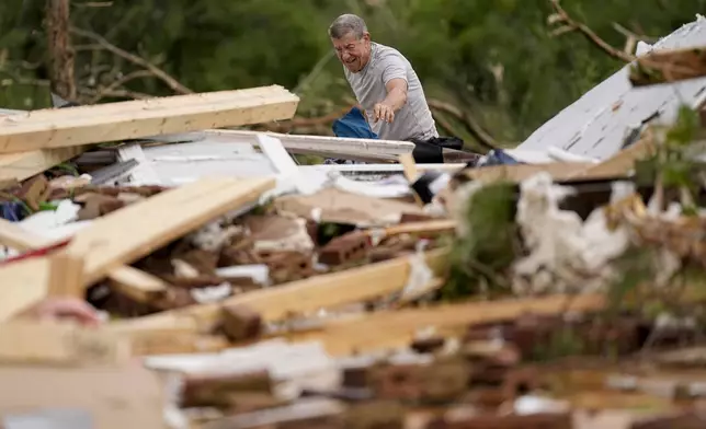 John Bernhardt picks up debris at his stormed damaged home Thursday, May 9, 2024, in Columbia, Tenn. A wave of dangerous storms began crashing over parts of the South on Thursday, a day after severe weather with damaging tornadoes killed several people in the region. (AP Photo/George Walker IV)
