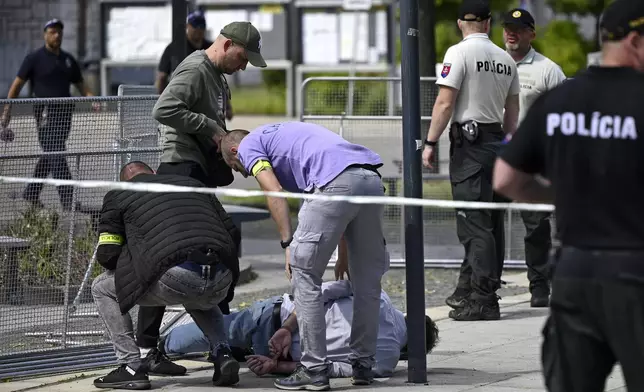 Police arrest a man after Slovak Prime Minister Robert Fico was shot and injured following the cabinet's away-from-home session in the town of Handlova, Slovakia, Wednesday, May 15, 2024. Fico is in life-threatening condition after being wounded in a shooting Wednesday afternoon, according to his Facebook profile. (Radovan Stoklasa/TASR via AP)