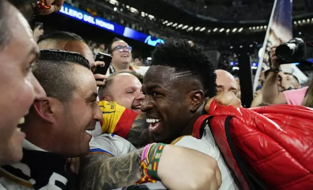 Real Madrid's Vinicius Junior celebrates with his supporters after winning the Champions League semifinal second leg soccer match between Real Madrid and Bayern Munich at the Santiago Bernabeu stadium in Madrid, Spain, Wednesday, May 8, 2024. Real Madrid won 2-1. (AP Photo/Jose Breton)