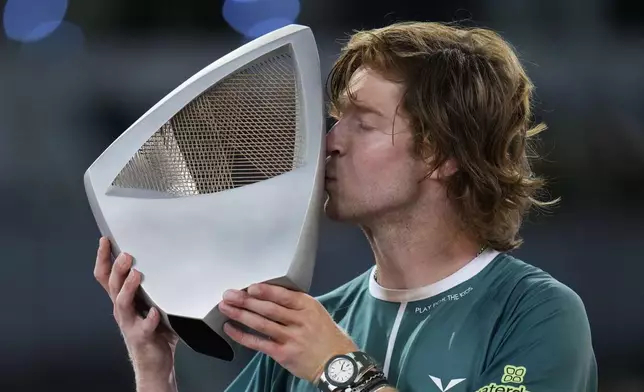 Andrey Rublev, of Russia kisses his trophy after winning against Felix Auger-Aliassime, of Canada, in the Madrid Open men's final match in Madrid, Spain, Sunday, May 5, 2024. (AP Photo/Manu Fernandez)