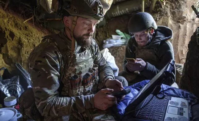 Ukrainian serviceman Andrii, left, of the Air Assault Forces 148th separate artillery brigade, sends receiving coordinates for a Furia drone at the frontline in Donetsk region, Ukraine, Thursday May 9, 2024. (AP Photo/Evgeniy Maloletka)