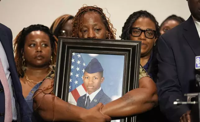 Chantimekki Fortson, mother of Roger Fortson, a U.S. Navy airman, holds a photo of her son during a news conference with Attorney Ben Crump, Thursday, May 9, 2024, in Fort Walton Beach, Fla. Fortson was shot and killed by police in his apartment on May 3, 2024. (AP Photo/Gerald Herbert)
