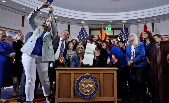 Ariz.. Rep. Stephanie Stahl Hamilton, takes a selfie with Arizona Gov. Katie Hobbs, after Hobbs signed the repeal of the Civil War-era near-total abortion ban to Thursday, May 2, 2024, at the Capitol in Phoenix. Democrats secured enough votes in the Arizona Senate to repeal the ban on abortions that the state's highest court recently allowed to take effect. (AP Photo/Matt York)