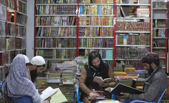 Afghans read books in a specialized religious bookstore in Kabul, Afghanistan, Wednesday, April 24, 2024. (AP Photo/Siddiqullah Alizai)