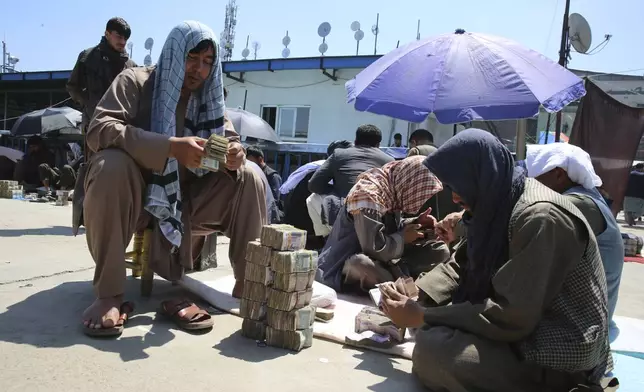 Afghan money changers wait for customers at a currency exchange market in Kabul, Afghanistan, Monday, April 22, 2024. (AP Photo/Siddiqullah Alizai)