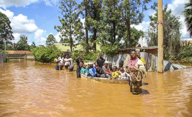 FILE - A family uses a boat after fleeing floodwaters that wreaked havoc in the Githurai area of Nairobi, Kenya, April 24, 2024. Extreme weather events have hit parts of Africa relentlessly in the last three years, with tropical storms, floods and drought causing crises of hunger and displacement. They leave another deadly threat behind them: some of the continent's worst outbreaks of cholera. In southern and East Africa, more than 6,000 people have died and nearly 350,000 cases have been reported since a series of cholera outbreaks began in late 2021. (AP Photo/Patrick Ngugi, File)