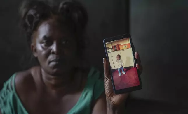 Mildred Banda holds a phone showing a picture of her one-year-old son who died of Cholera in Lilanda township in Lusaka, Zambia, Saturday, March, 9, 2024. Lilanda, an impoverished township on the edge of the Zambian capital of Lusaka, is a typical cholera hotspot. Stagnant pools of water dot the dirt roads. Clean water is gold dust. Extreme weather events have hit parts of Africa relentlessly in the last three years, with tropical storms, floods and drought causing crises of famine and displacement, and leaving another deadly threat in their aftermath: some of the continent's worst outbreaks of cholera. (AP Photo/Tsvangirayi Mukwazhi)