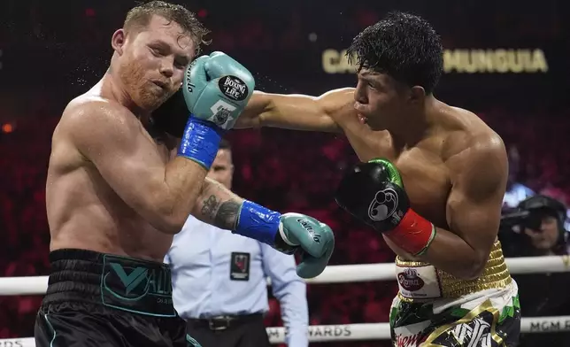Jaime Munguia hits Canelo Alvarez in a super middleweight title fight Saturday, May 4, 2024, in Las Vegas. (AP Photo/John Locher)