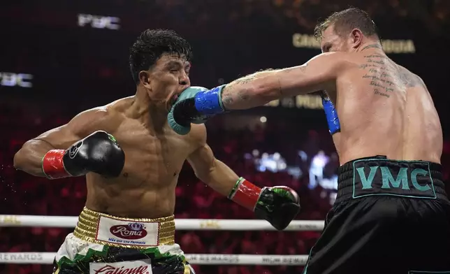 Canelo Alvarez hits Jaime Munguia in a super middleweight title fight Saturday, May 4, 2024, in Las Vegas. (AP Photo/John Locher)