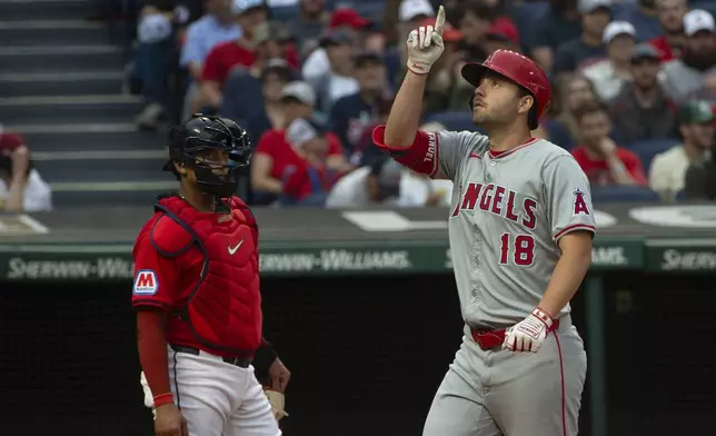 Cleveland Guardians' Bo Naylo, left, looks on as Los Angeles Angels' Nolan Schanuel (18) gestures after hitting a solo home run off Guardians starting pitcher Tanner Bibee during the third inning of a baseball game in Cleveland, Friday, May 3, 2024. (AP Photo/Phil Long)