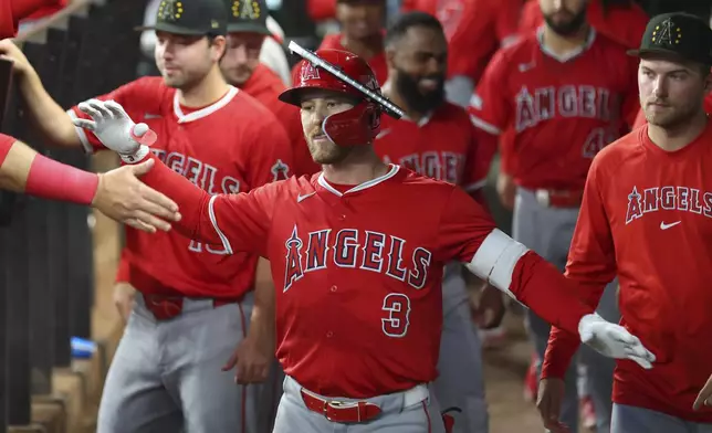 Los Angeles Angels Taylor Ward (3) celebrates in the dugout after a solo home run against the Texas Rangers in the fourth inning of a baseball game Saturday, May 18, 2024, in Arlington, Texas. (AP Photo/Richard W. Rodriguez)