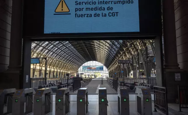 An electronic sign with the Spanish message "Service interrupted by forced measures by the CGT," referring to the workers union strike against the reforms of President Javier Milei, at the Retiro train station that is empty due to the strike in Buenos Aires, Argentina, Thursday, May 9, 2024. (AP Photo/Rodrigo Abd)