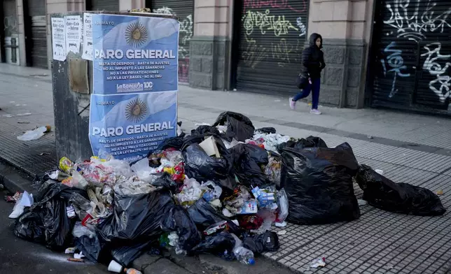 Garbage that city workers have not picked up accumulates outside Constitution Station next to stores that are closed due to a general strike against the reforms of President Javier Milei in Buenos Aires, Argentina, Thursday, May 9, 2024. (AP Photo/Natacha Pisarenko)