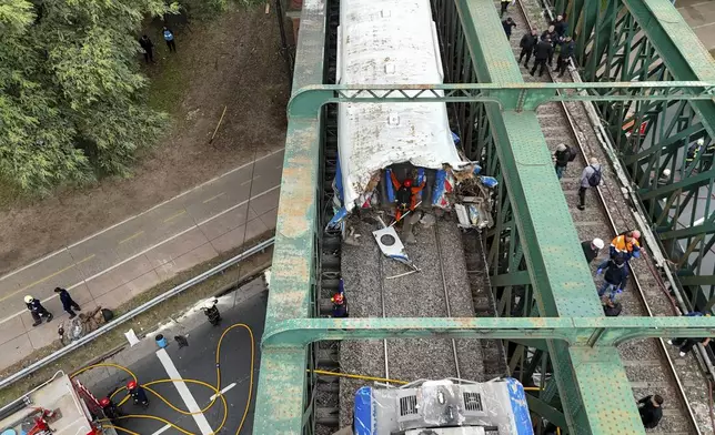 Railway workers inspect a passenger train after it collided with another in Buenos Aires, Argentina, Friday, May 10, 2024. (AP Photo/Franco Dergarabedian)