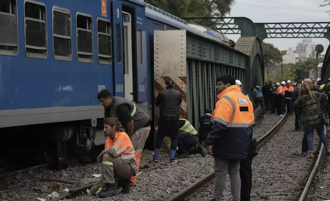 Railway workers inspect a passenger train after it collided with another in Buenos Aires, Argentina, Friday, May 10, 2024. (AP Photo/Rodrigo Abd)