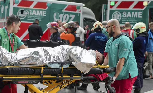 Paramedics transport injured commuters after two trains collided in Buenos Aires, Argentina, Friday, May 10, 2024. (AP Photo/Natacha Pisarenko)