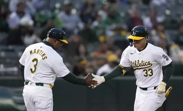 Oakland Athletics' JJ Bleday, right, celebrates with third base coach Eric Martins after hitting a solo home run against the Houston Astros during the fifth inning of a baseball game Friday, May 24, 2024, in Oakland, Calif. (AP Photo/Godofredo A. Vásquez)