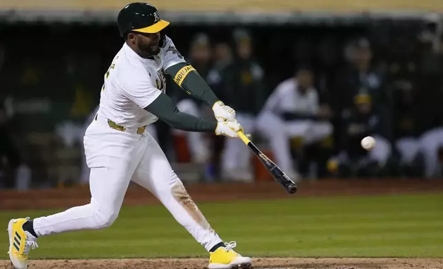 Oakland Athletics' Miguel Andujar hits an RBI single against the Houston Astros during the seventh inning of a baseball game Friday, May 24, 2024, in Oakland, Calif. (AP Photo/Godofredo A. Vásquez)