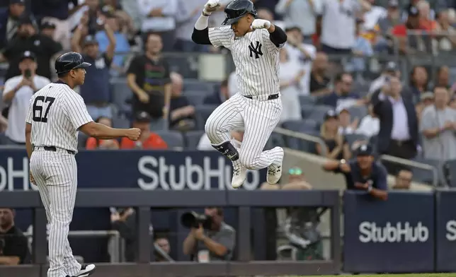 New York Yankees' Juan Soto celebrates with third base coach Luis Rojas (67) after hitting a two-run home run against the Houston Astros during the first inning of a baseball game Wednesday, May 8, 2024, in New York. (AP Photo/Adam Hunger)