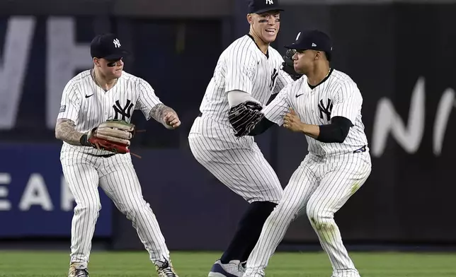 New York Yankees' Aaron Judge, center, Juan Soto and Alex Verdugo, left, celebrate after the Yankees defeated the Houston Astros in a baseball game Wednesday, May 8, 2024, in New York. (AP Photo/Adam Hunger)