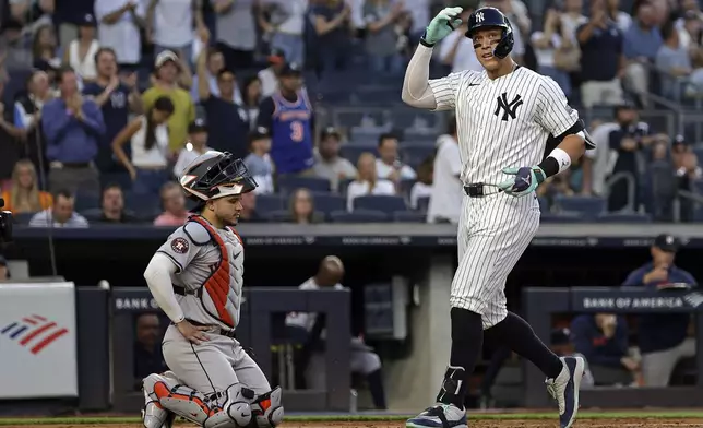 New York Yankees' Aaron Judge celebrates his home run as he crosses home plate past Houston Astros catcher Yainer Diaz during the third inning of a baseball game Wednesday, May 8, 2024, in New York. (AP Photo/Adam Hunger)