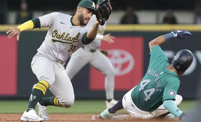 Oakland Athletics second baseman Abraham Toro (31) goes to tag Seattle Mariners' Julio Rodríguez on a steal attmpt during the sixth inning of a baseball game Saturday, May 11, 2024, in Seattle. Rodríguez was tagged out after coming off the bag. (AP Photo/Jason Redmond)