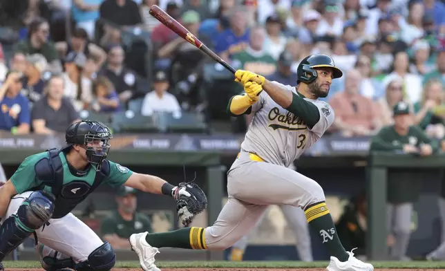 Oakland Athletics' Abraham Toro watches his RBI single next to Seattle Mariners catcher Cal Raleigh during the third inning of a baseball game Saturday, May 11, 2024, in Seattle. (AP Photo/Jason Redmond)