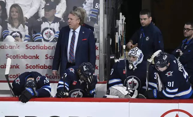 Winnipeg Jets' head coach Rick Bowness, left center, and players react at the end of Game 5 of an NHL hockey Stanley Cup first-round playoff series against the Colorado Avalanche in Winnipeg, Manitoba, Tuesday April 30, 2024. (Fred Greenslade/The Canadian Press via AP)