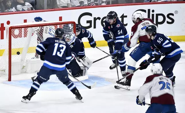 Colorado Avalanche Yakov Trenin (73) scores on Winnipeg Jets goaltender Connor Hellebuyck (37) during the second period in Game 5 of an NHL hockey Stanley Cup first-round playoff series in Winnipeg, Manitoba, Tuesday, April 30, 2024. (Fred Greenslade/The Canadian Press via AP)