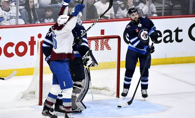 Winnipeg Jets' Neal Poink (4) takes the puck out of the net after a goal by Colorado Avalanche's Artturi Lehkonen during the second period in Game 5 of an NHL hockey Stanley Cup first-round playoff series in Winnipeg, Manitoba, Tuesday, April 30, 2024. (Fred Greenslade/The Canadian Press via AP)
