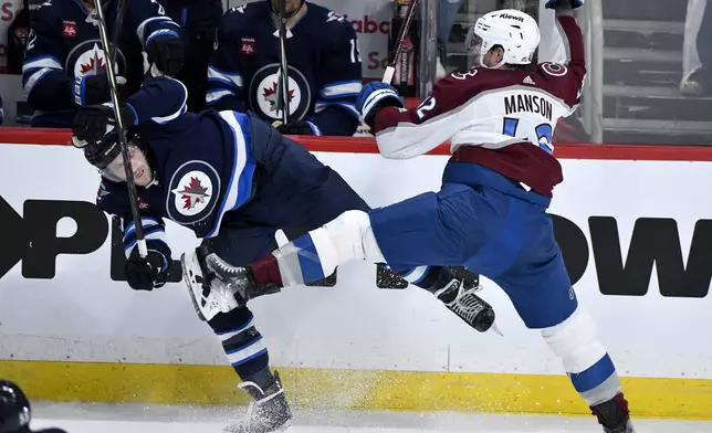 Colorado Avalanche's Josh Manson (42) and Winnipeg Jets' Nikolaj Ehlers (27) collide during the second period in Game 5 of an NHL hockey Stanley Cup first-round playoff series in Winnipeg, Manitoba, Tuesday, April 30, 2024. (Fred Greenslade/The Canadian Press via AP)