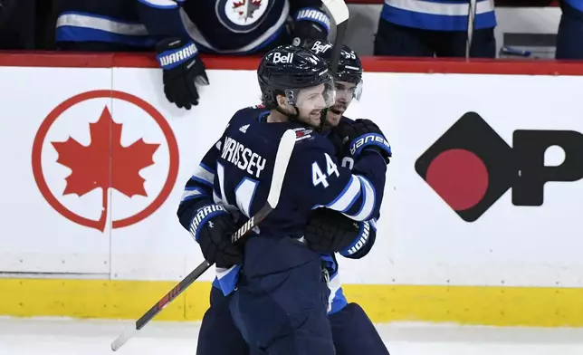 Winnipeg Jets' Josh Morrissey (44) celebrates his goal against the Colorado Avalanche with Mark Scheifele (55) during the second period in Game 5 of an NHL hockey Stanley Cup first-round playoff series in Winnipeg, Manitoba, Tuesday, April 30, 2024. (Fred Greenslade/The Canadian Press via AP)
