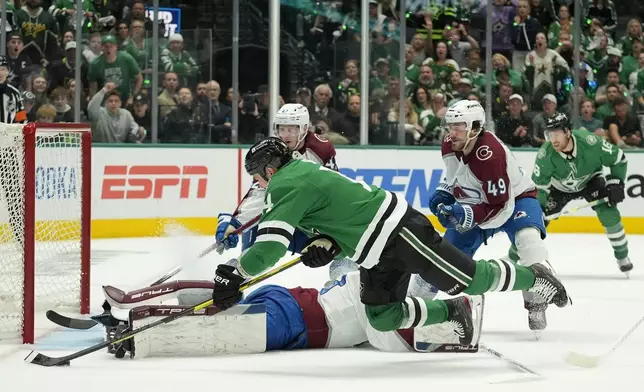 Dallas Stars left wing Jamie Benn, front, makes a diving shot attempt as Colorado Avalanche goaltender Alexandar Georgiev, on ice, and Samuel Girard (49) defend on the play in the first period in Game 2 of an NHL hockey Stanley Cup second-round playoff series in Dallas, Tuesday, May 7, 2024. (AP Photo/LM Otero)