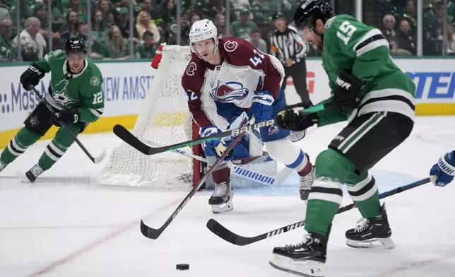 Colorado Avalanche defenseman Josh Manson (42) helps defend the net against pressure from Dallas Stars center Craig Smith (15) and center Radek Faksa (12) in the first period in Game 2 of an NHL hockey Stanley Cup second-round playoff series in Dallas, Tuesday, May 7, 2024. (AP Photo/LM Otero)