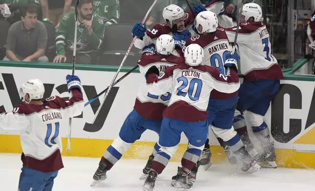 Colorado Avalanche's Andrew Cogliano (11), Nathan MacKinnon (29), Ross Colton (20), Mikko Rantanen (96), Casey Mittelstadt and Miles Wood, center rear, celebrate after Wood scored in overtime in Game 2 of an NHL hockey Stanley Cup second-round playoff series against the Dallas Stars in Dallas, Tuesday, May 7, 2024. (AP Photo/LM Otero)