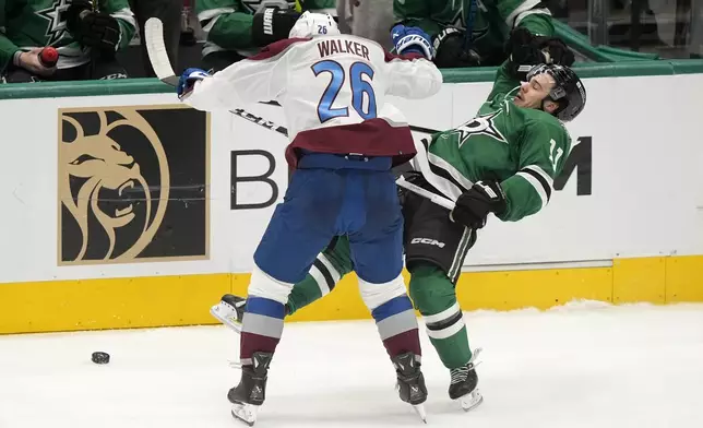 Dallas Stars center Logan Stankoven (11) takes a big hit from Colorado Avalanche defenseman Sean Walker (26) as they compete for the puck in the third period in Game 2 of an NHL hockey Stanley Cup second-round playoff series in Dallas, Tuesday, May 7, 2024. (AP Photo/LM Otero)