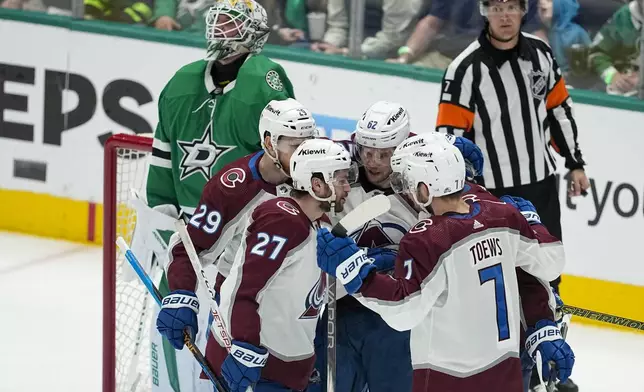 Colorado Avalanche's Nathan MacKinnon (29), Jonathan Drouin (27), Devon Toews (7), Artturi Lehkonen (62) and Cale Makar (8) react after Makar scored a goal against Dallas Stars goaltender Jake Oettinger, top, during the third period in Game 5 of an NHL hockey Stanley Cup second-round playoff series, Wednesday, May 15, 2024, in Dallas. (AP Photo/Tony Gutierrez)