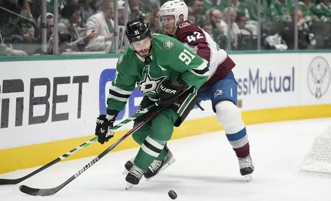 Dallas Stars center Tyler Seguin (91) and Colorado Avalanche defenseman Josh Manson (42) compete for the puck during the first period in Game 2 of an NHL hockey Stanley Cup second-round playoff series in Dallas, Thursday, May 9, 2024. (AP Photo/Tony Gutierrez)