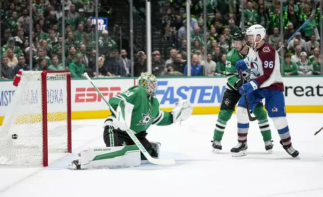 Colorado Avalanche right wing Mikko Rantanen (96) eyes the puck after a power play scoring shot by teammate Cale Makar, not visible, during the second period in Game 5 of an NHL hockey Stanley Cup second-round playoff series against the Dallas Stars, Wednesday, May 15, 2024, in Dallas. Looking on are Stars' Jake Oettinger (29) and Esa Lindell (23). (AP Photo/Tony Gutierrez)