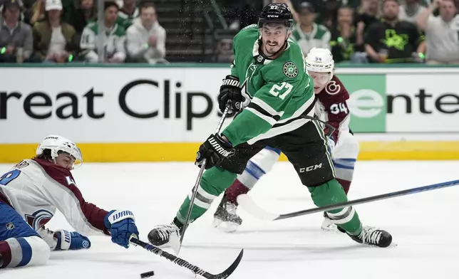 Dallas Stars left wing Mason Marchment (27) shoots as Colorado Avalanche's Samuel Girard, left, defends in the first period in Game 2 of an NHL hockey Stanley Cup second-round playoff series in Dallas, Thursday, May 9, 2024. (AP Photo/Tony Gutierrez)