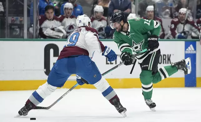 Dallas Stars center Craig Smith (15) passes the pucks as Colorado Avalanche's Nathan MacKinnon (29) defends during the first period in Game 2 of an NHL hockey Stanley Cup second-round playoff series in Dallas, Thursday, May 9, 2024. (AP Photo/Tony Gutierrez)