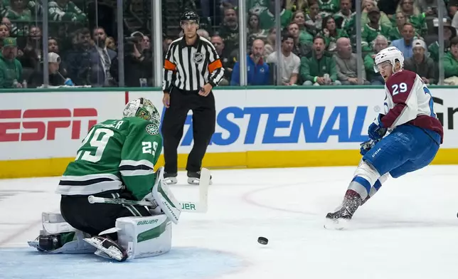 Colorado Avalanche center Nathan MacKinnon, right, watches the puck after his shot was blocked by Dallas Stars goaltender Jake Oettinger during the second period in Game 5 of an NHL hockey Stanley Cup second-round playoff series, Wednesday, May 15, 2024, in Dallas. (AP Photo/Tony Gutierrez)