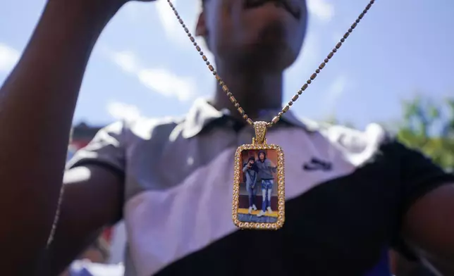 Jah Johnson holds a necklace displaying a picture of him and Antonio Lee following a funeral service for Lee, Thursday, Aug. 31, 2023, in Baltimore. Lee, 19, a squeegee worker was killed during a shooting as he panhandled in a Baltimore street corner. (AP Photo/Julio Cortez)