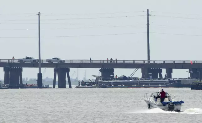 Officials respond after the Pelican Island Bridge was closed when a passing barge struck one of its supports, Wednesday, May 15, 2024, in Galveston, Texas. The accident caused oil to spill into surrounding waters and closing the only road to a smaller and separate island that is home to a university, officials said. (Jon Shapley/Houston Chronicle via AP)
