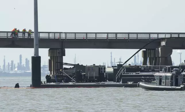 Officials respond after the Pelican Island Bridge was closed when a passing barge struck one of its supports, Wednesday, May 15, 2024, in Galveston, Texas. The accident caused oil to spill into surrounding waters and closing the only road connecting the city to Pelican Island. (Jon Shapley/Houston Chronicle via AP)