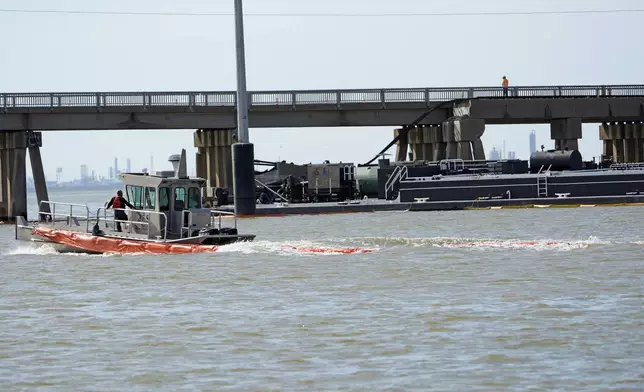 An spill boom is moved into position to contain a leak from a barge that crashed into the Pelican Island Bridge, Wednesday, May 15, 2024, in Galveston, Texas. (AP Photo/David J. Phillip)