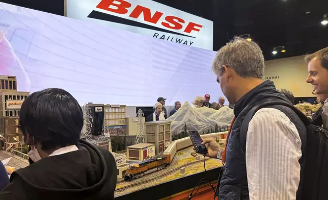 Berkshire Hathaway shareholders watch a model BNSF train run past a model town filled with other Berkshire companies Friday, May 3, 2024, in Omaha, Neb. Buffett will spend hours answering questions at a meeting Saturday. (AP Photo/Josh Funk)