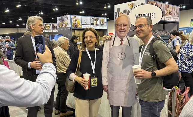 Berkshire Hathaway shareholders pose with a cutout poster of CEO Warren Buffett, Friday, May 3, 2024, in Omaha, Neb., one day ahead of the annual shareholders meeting. (AP Photo/Josh Funk)